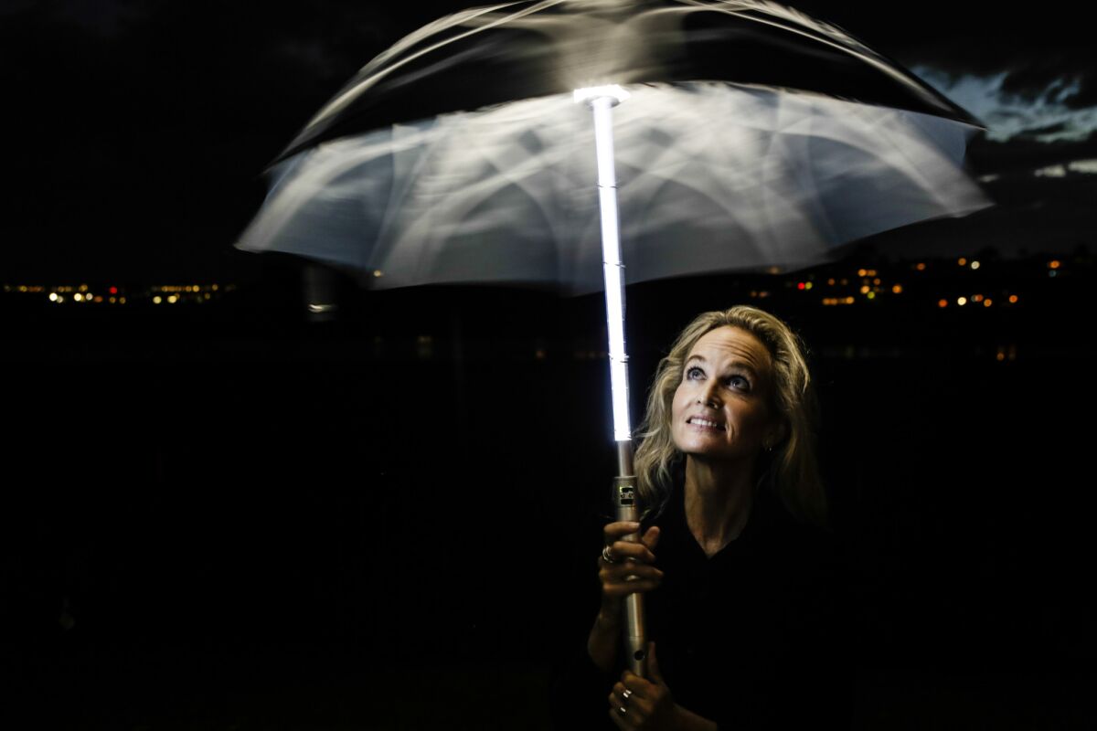 Artist Elizabeth Turk twirls her light-up umbrella.