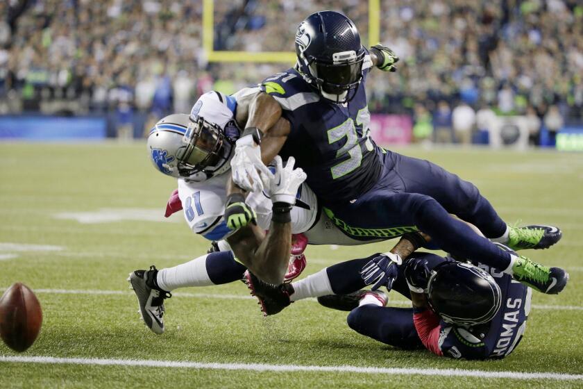 Detroit wide receiver Calvin Johnson, left, loses the ball at the goal line on a hit by Seattle safety Kam Chancellor on Monday night.