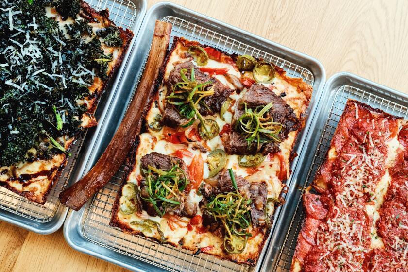 Three square pizzas on a table at Seven Tigers Pie Club in Koreatown: one with kale, one with galbi, one with pepperoni.
