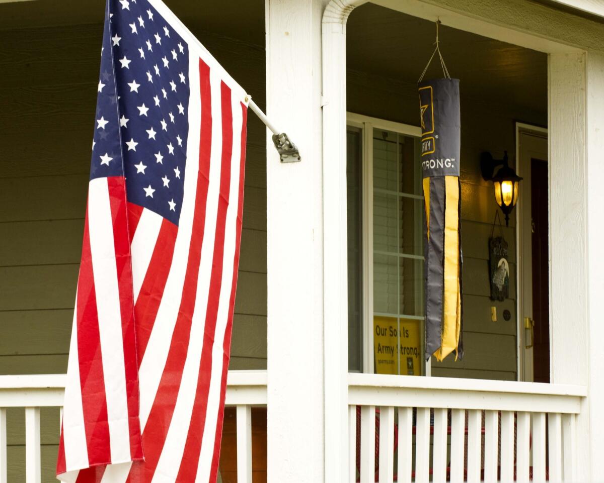 An American flag and an Army windsock fly at a home in Walla Walla, Wash.