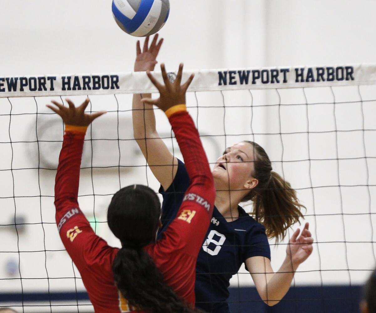 Newport Harbor's Sadie Henderson (18) tips a ball past Long Beach Wilson blocker Emiya Green (13) on Wednesday.