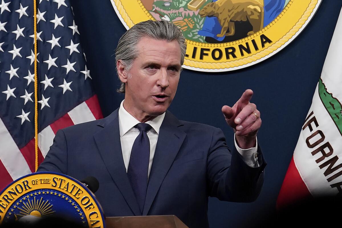 A man at a lectern points with his left hand.
