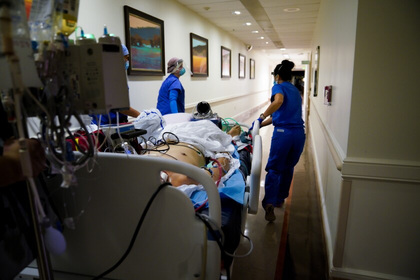 Staff members take a COVID-19 patient to intensive care at UCSD Health's Jacobs Medical Center in La Jolla in June 2020.