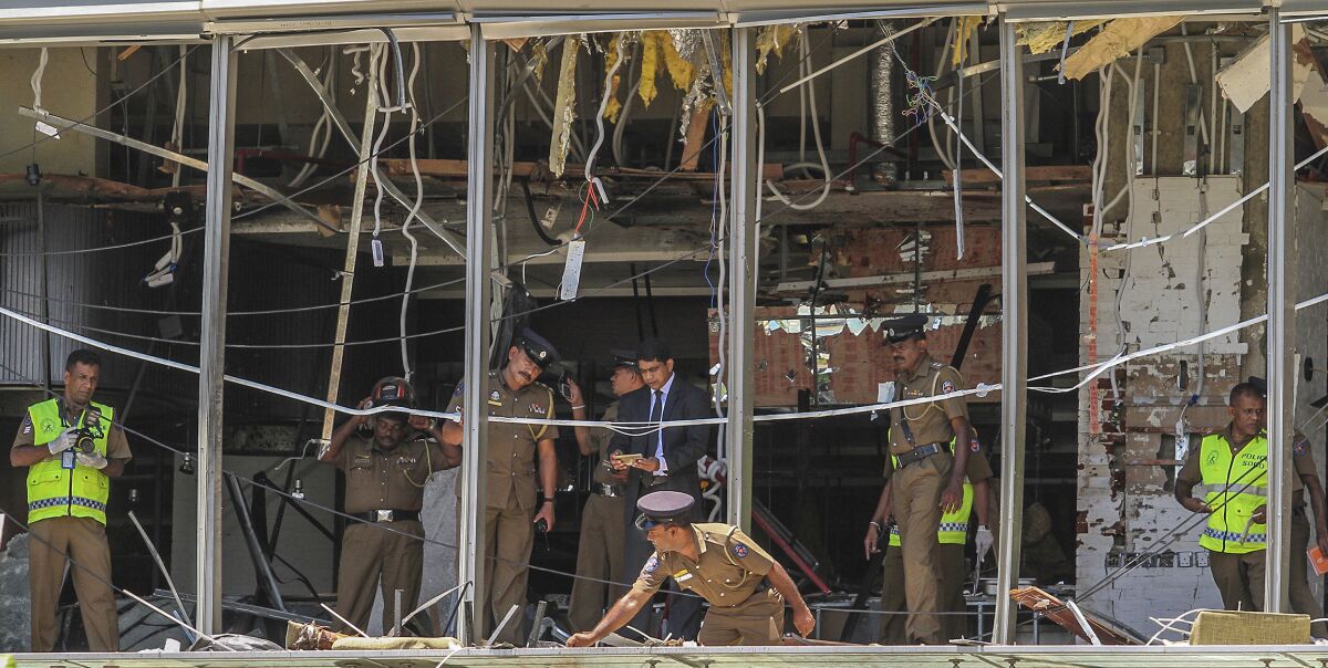 FILE- In this Sunday April 21, 2019, file photo, Sri Lankan police officers inspect the site of an explosion at the Shangri-la hotel in Colombo, Sri Lanka. Sri Lanka has filed 23,270 charges against 25 people in connection with the 2019 Easter Sunday suicide bomb attacks on churches and hotels that killed 269 people, the president’s office said Wednesday, Aug. 11, 2021. (AP Photo/Chamila Karunarathne, file)