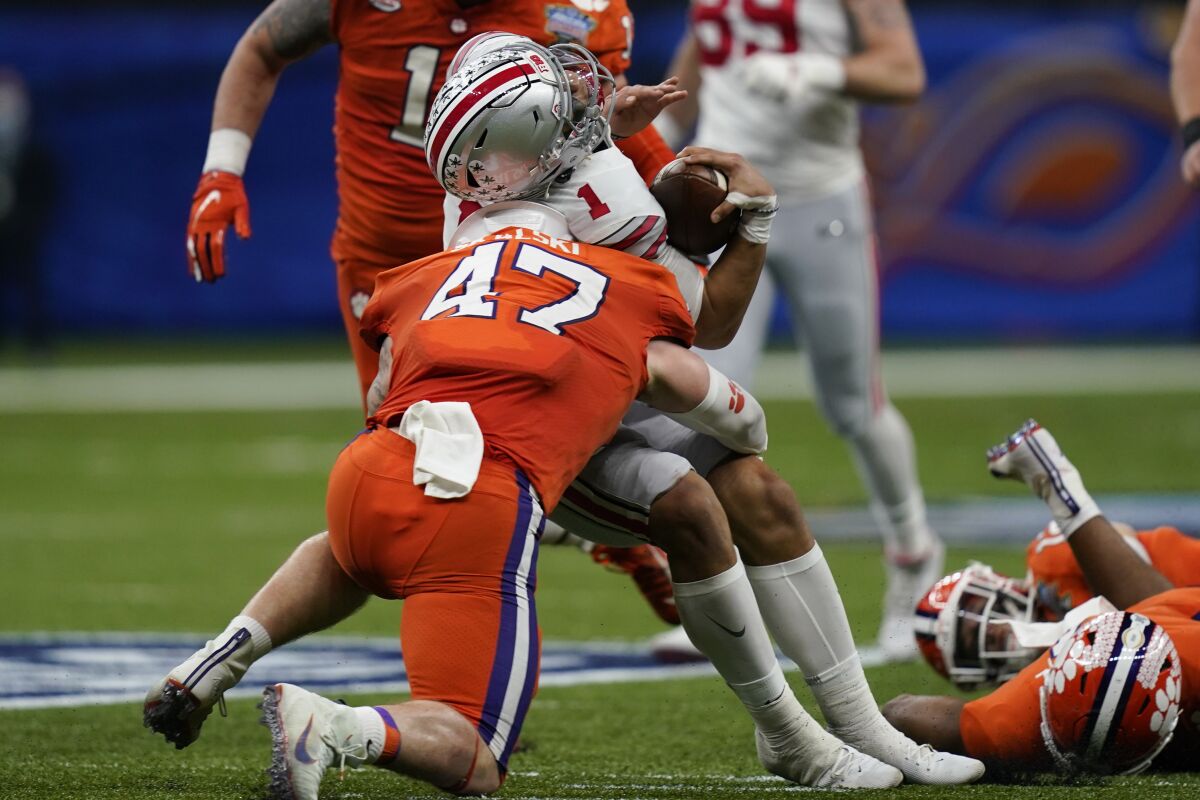 FILE - Ohio State quarterback Justin Fields gets hit by Clemson linebacker James Skalski during the first half of the Sugar Bowl NCAA college football game Friday, Jan. 1, 2021, in New Orleans. Skalski was ejected from the game for targeting. Players ejected for targeting in the second half of a college football game could be eligible to play the following game after an appeal through the conference office if a recommendation handed down Friday, March 4, 2022 by the NCAA rules committee is approved.(AP Photo/Gerald Herbert, File)