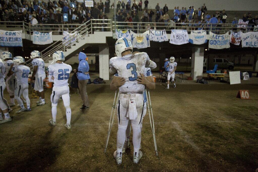 Corona del Mar's Chase Garbers hugs an injured Bryan Samudro after the Sea Kings lost to Buena Park.