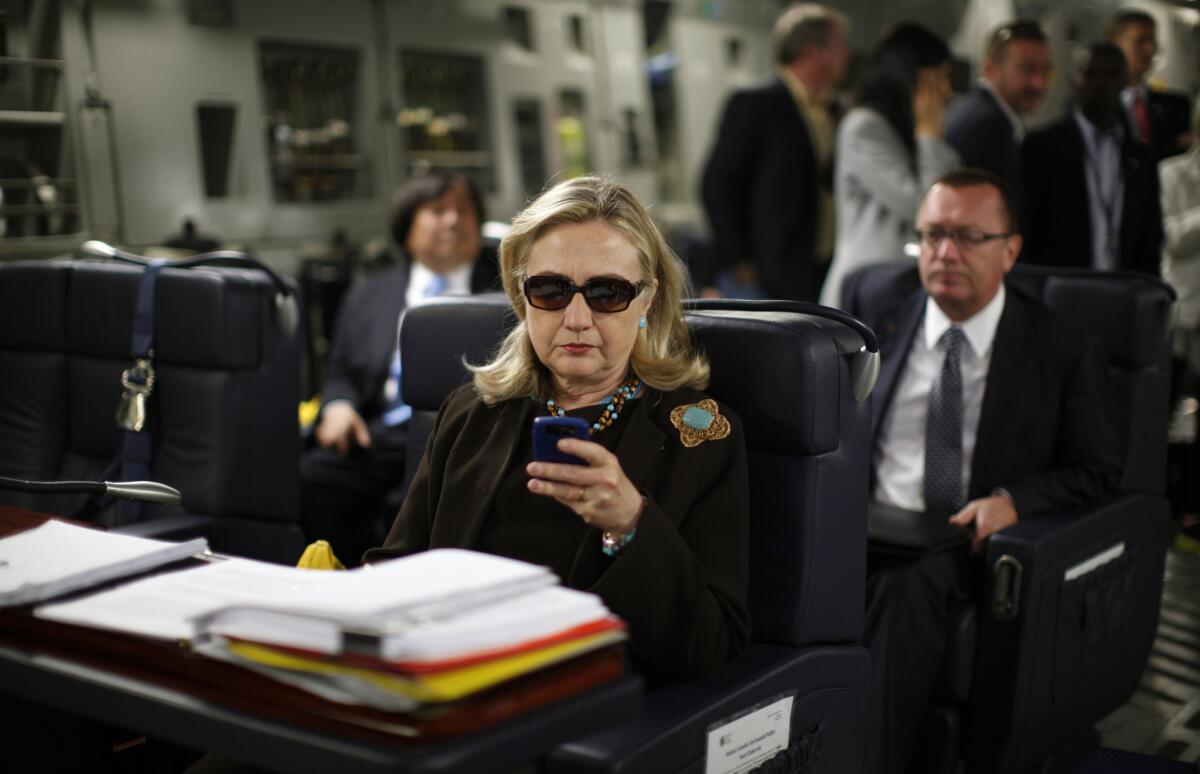 Then-Secretary of State Hillary Clinton checks her Blackberry from a desk inside a C-17 military plane upon her departure from Malta in 2011.