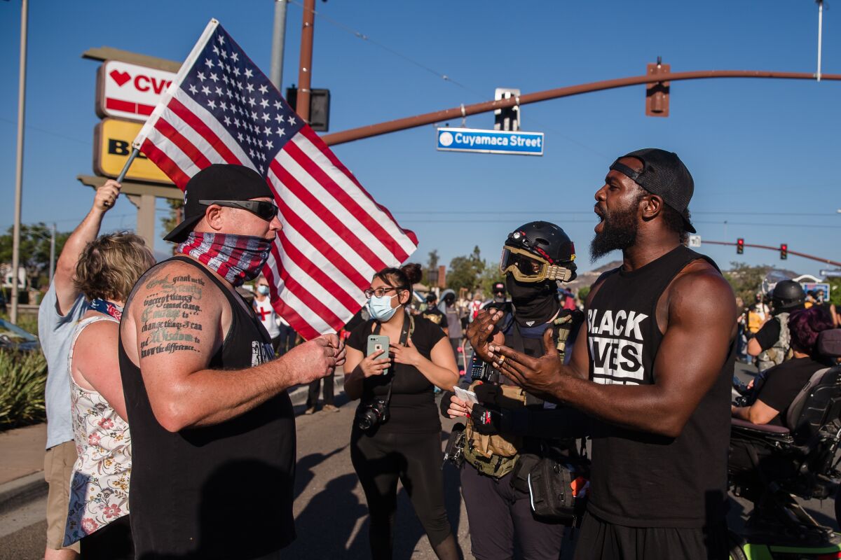 Counter-protesters and attendees speak at a protest in Santee in August 29
