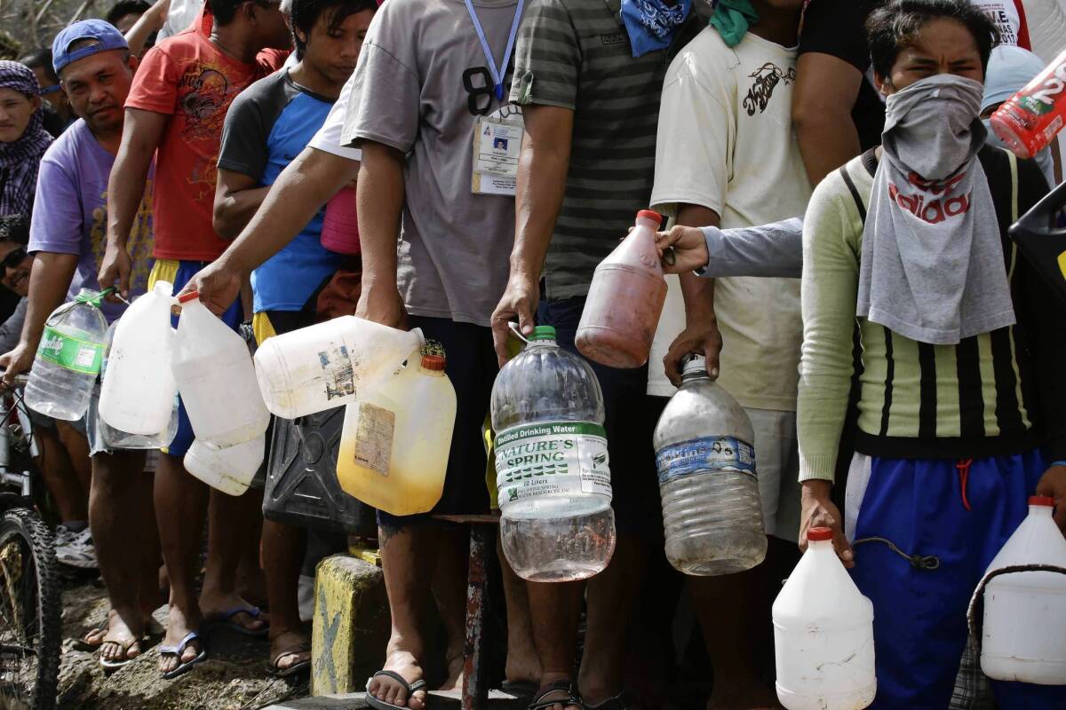 Filipinos line up to get fuel at an abandoned gas station in Tacloban.