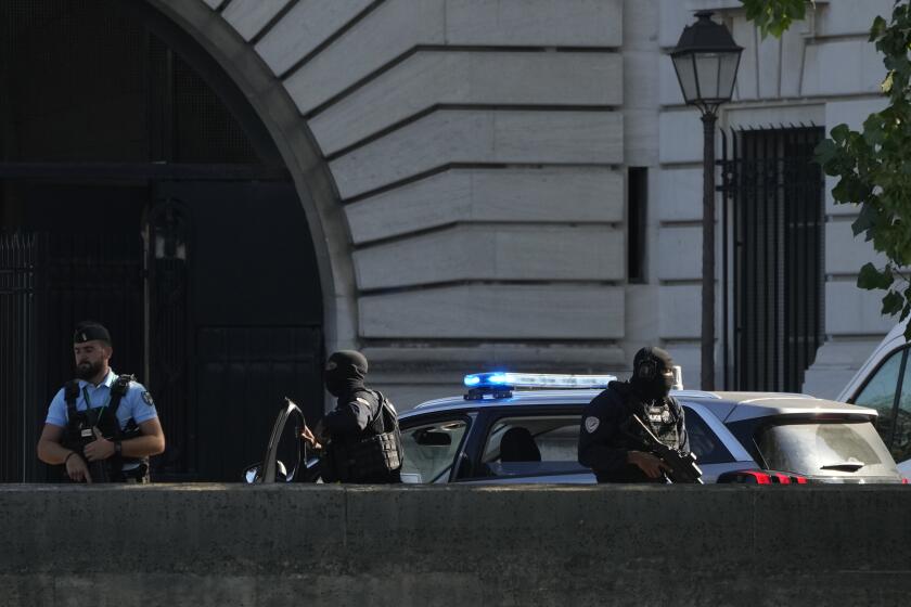 Security forces guard an entrance of the Palace of Justice Wednesday, Sept. 8, 2021 in Paris. France is putting on trial 20 men accused in the Islamic State group's 2015 attacks on Paris that left 130 people dead and hundreds injured. The proceedings begin Wednesday in an enormous custom-designed chamber. Most of the defendants face the maximum sentence of life in prison if convicted of complicity in the attacks. Only Abdeslam is charged with murder. (AP Photo/Francois Mori)