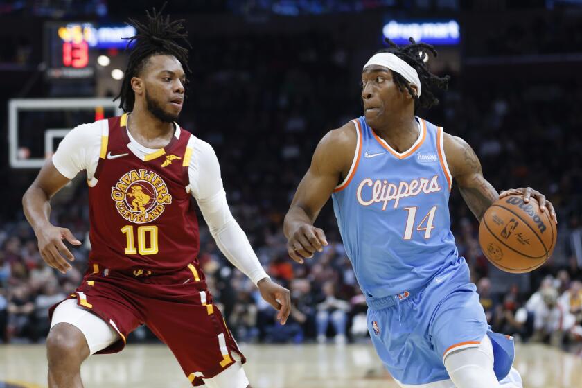 Los Angeles Clippers' Terance Mann (14) drives against Cleveland Cavaliers' Darius Garland (10) during the first half of an NBA basketball game, Monday, March 14, 2022, in Cleveland. (AP Photo/Ron Schwane)