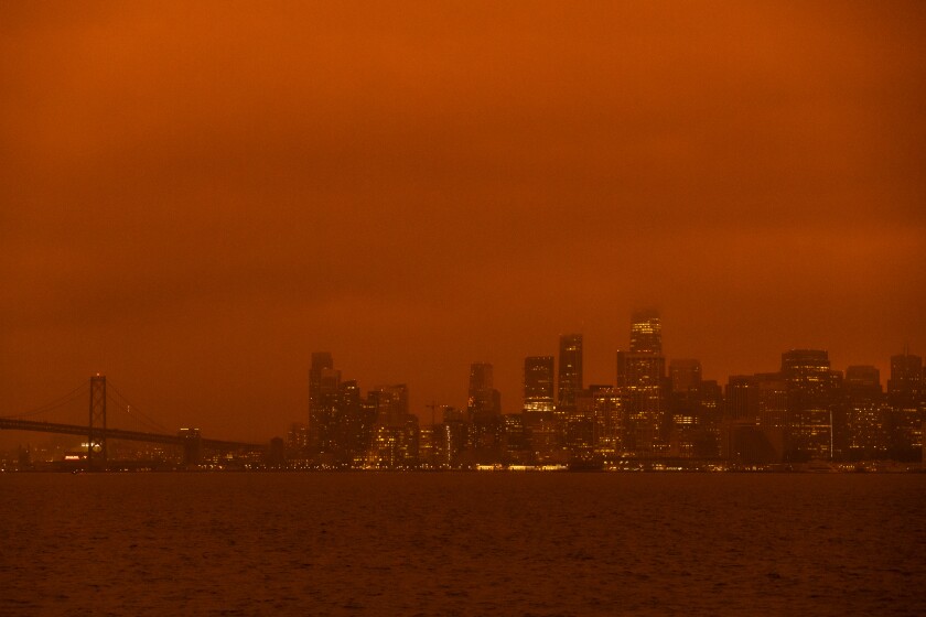 The San Francisco skyline is shrouded in an orange haze