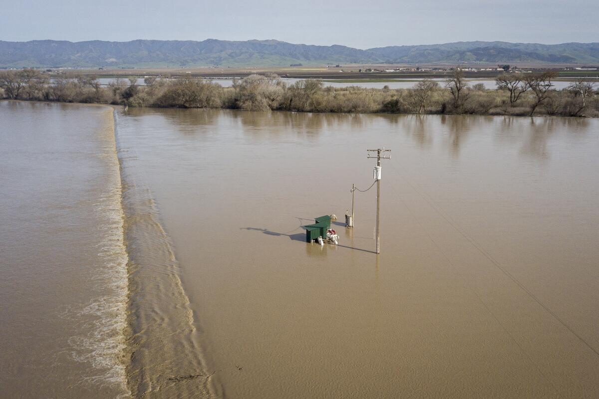 A lone electricity pole standing in floodwater