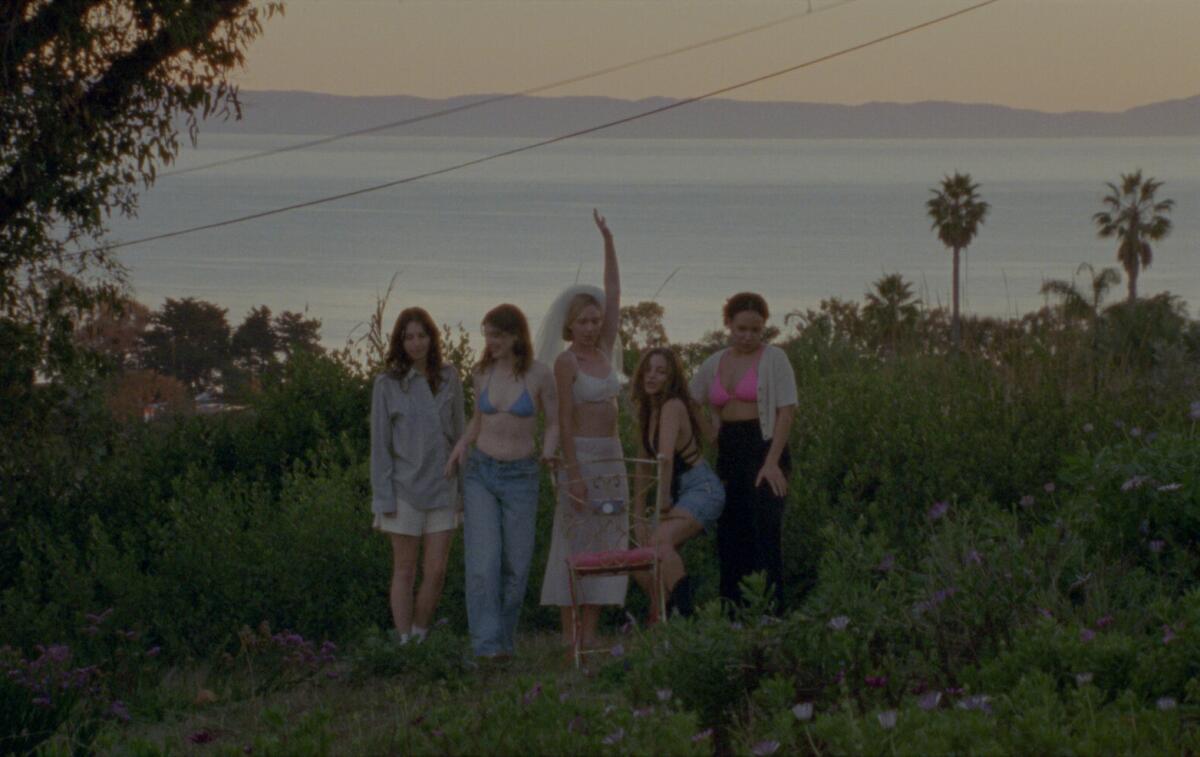 Several women stand together in a field.