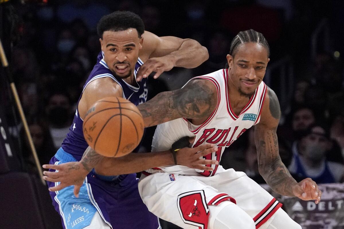 Lakers guard Talen Horton-Tucker, left, and Bulls forward DeMar DeRozan try to track down a loose ball.