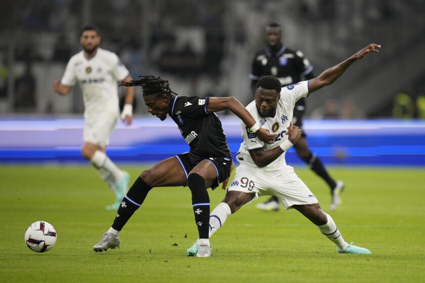 Auxerre's Nuno da Costa, left, challenges for the ball with Marseille's Chancel Mbemba during the French League One soccer match between Marseille and Auxerre at the Velodrome stadium in Marseille, France, Sunday, April 30, 2023. (AP Photo/Daniel Cole)
