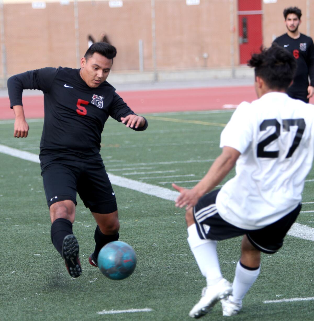 Glendale High School soccer player Elijah Cruz clears the ball in game vs. Burroughs High at home in Glendale on Tuesday, Jan. 21, 2020.