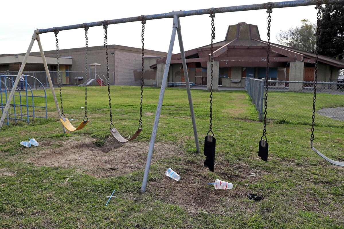 An aged and weathered swing set where kindergarteners once played at Park View School in Huntington Beach.