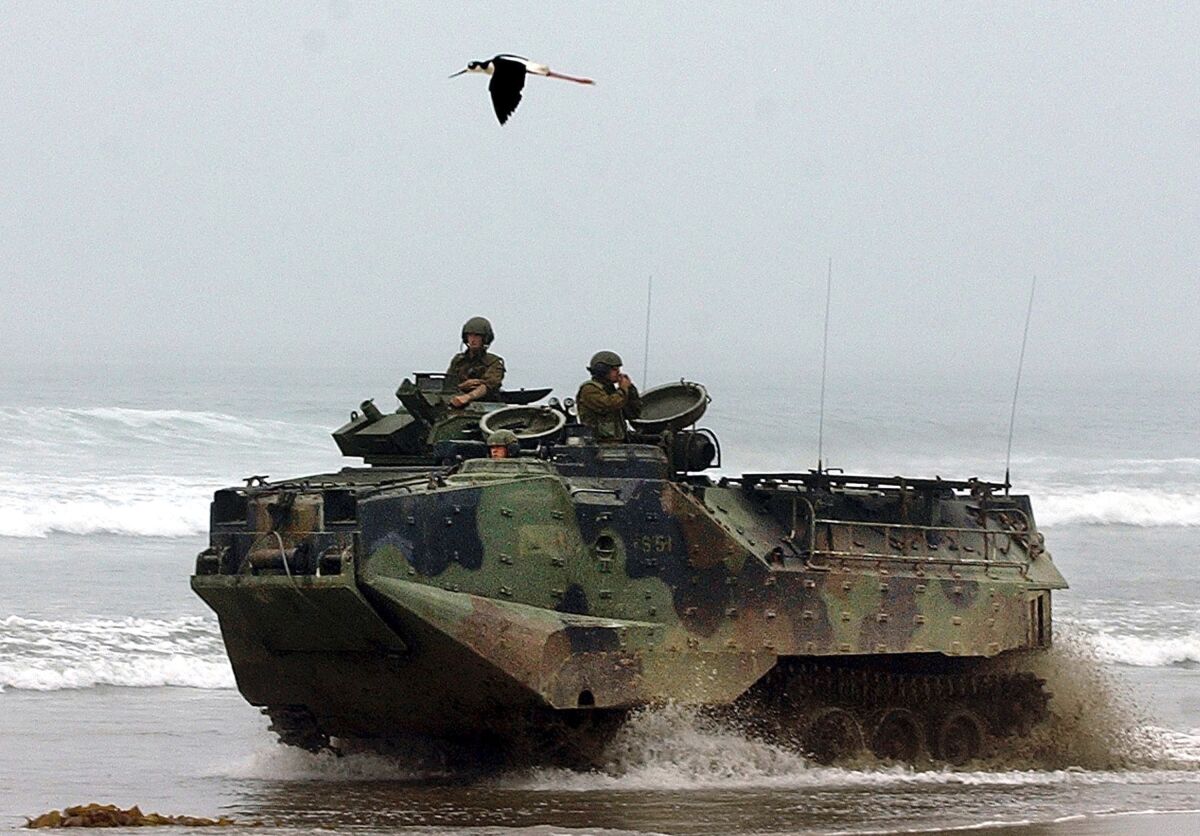 FILE - In this July, 2, 2003., file photo, a U.S. Marine Corps amphibious assault vehicle drives past a marked endangered species area as a black-necked Stilt, flies overhead at Red Beach on Camp Pendleton Marine Corps Base, Calif. Marines are training in seafaring tanks for the first time since nine men died when when one of the troop carriers sank off the Southern California coast during an exercise on July 30, 2020. The Orange County Register reports Marines from Camp Pendleton resumed exercises in water recovery and troop transfers, without troops in early April 2021. The Marine Corps has said that last year's accident was caused by inadequate training, shabby maintenance and poor judgment by commanders. (AP Photo/Denis Poroy, File)