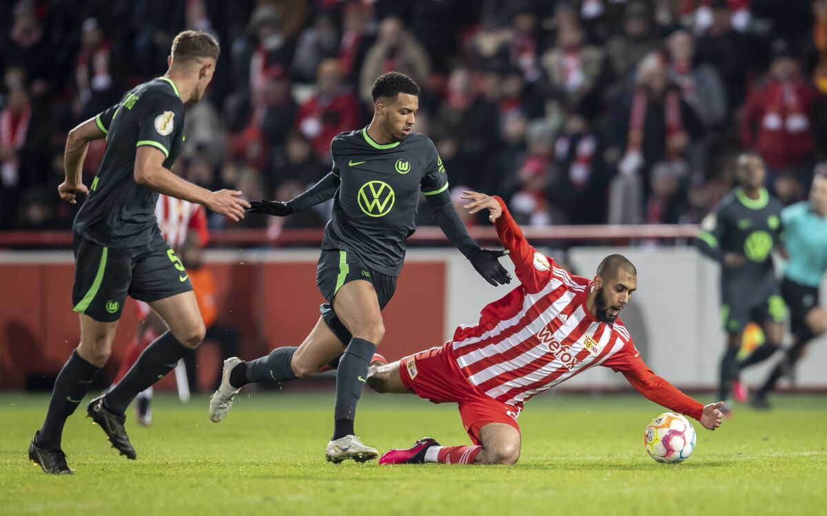 FC Union Berlin's Aissa Laidouni, right, and VfL Wolfsburg's Felix Nmecha fight for the ball during a German Cup soccer match, Tuesday, Jna. 31, 2023, in Berlin. (Andreas Gora/dpa via AP)