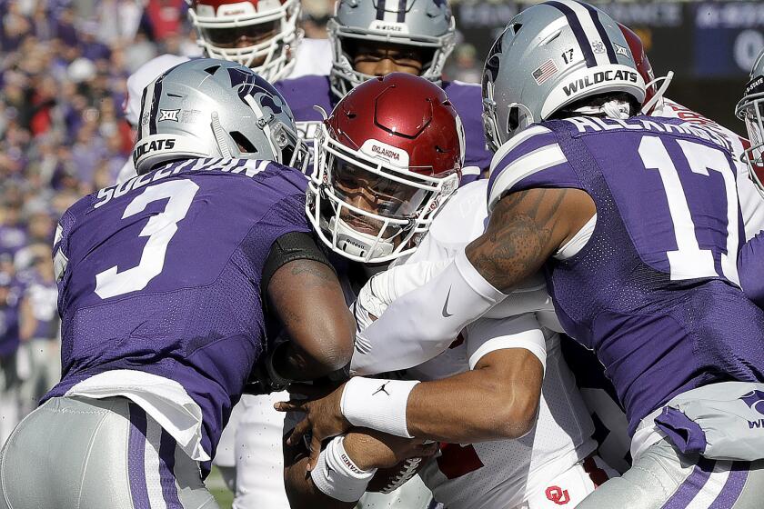 Oklahoma quarterback Jalen Hurts, center pushes his way into the end zone to score a touchdown during the first half of an NCAA college football game against Kansas State Saturday, Oct. 26, 2019, in Manhattan, Kan. (AP Photo/Charlie Riedel)
