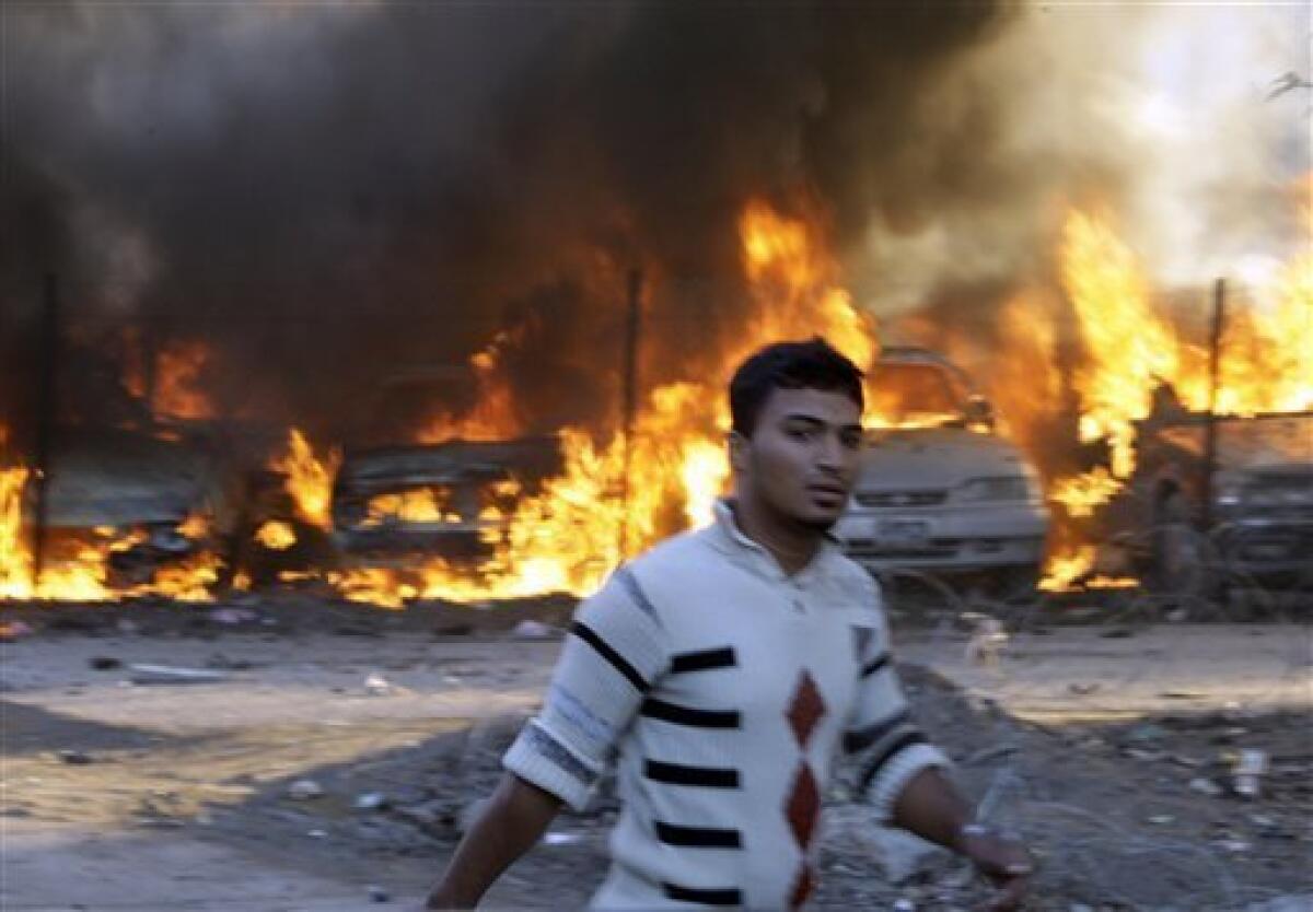 An Iraqi man passes by the site of a car bomb attack in Baghdad, Iraq, Tuesday, Dec. 15, 2009. A series of car bombs ripped through downtown Baghdad near the heavily fortified Green Zone. (AP Photo/Hadi Mizban)