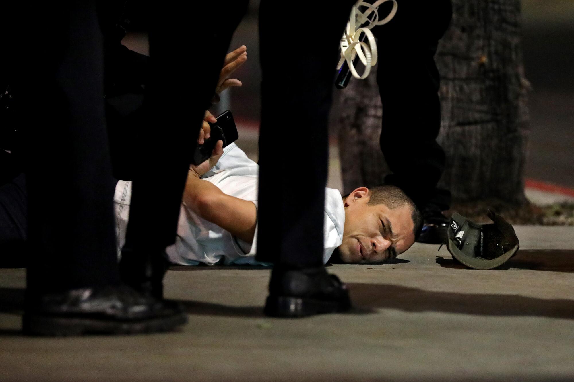 A protester is arrested for violating curfew at Sunset Boulevard in Los Angeles.
