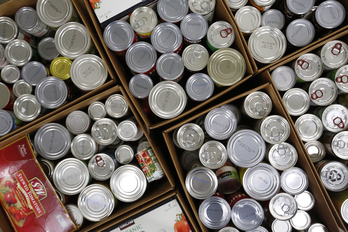 Canned food is stacked in the sorting room at the Jacobs & Cushman San Diego Food Bank on April 14, 2020.