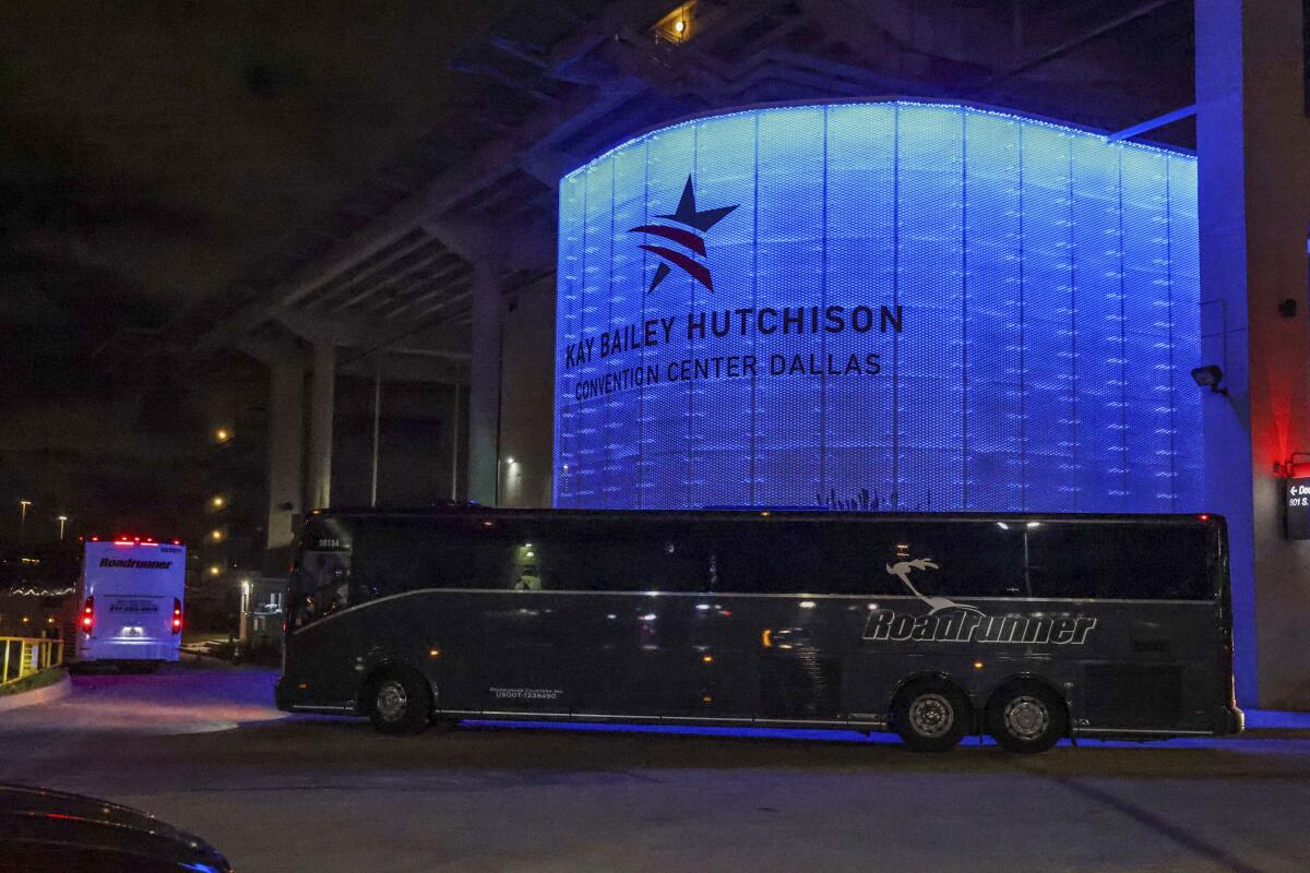 Charter buses arrive at the Kay Bailey Hutchison Convention Center in Dallas, escorted by the Federal Protective Service.