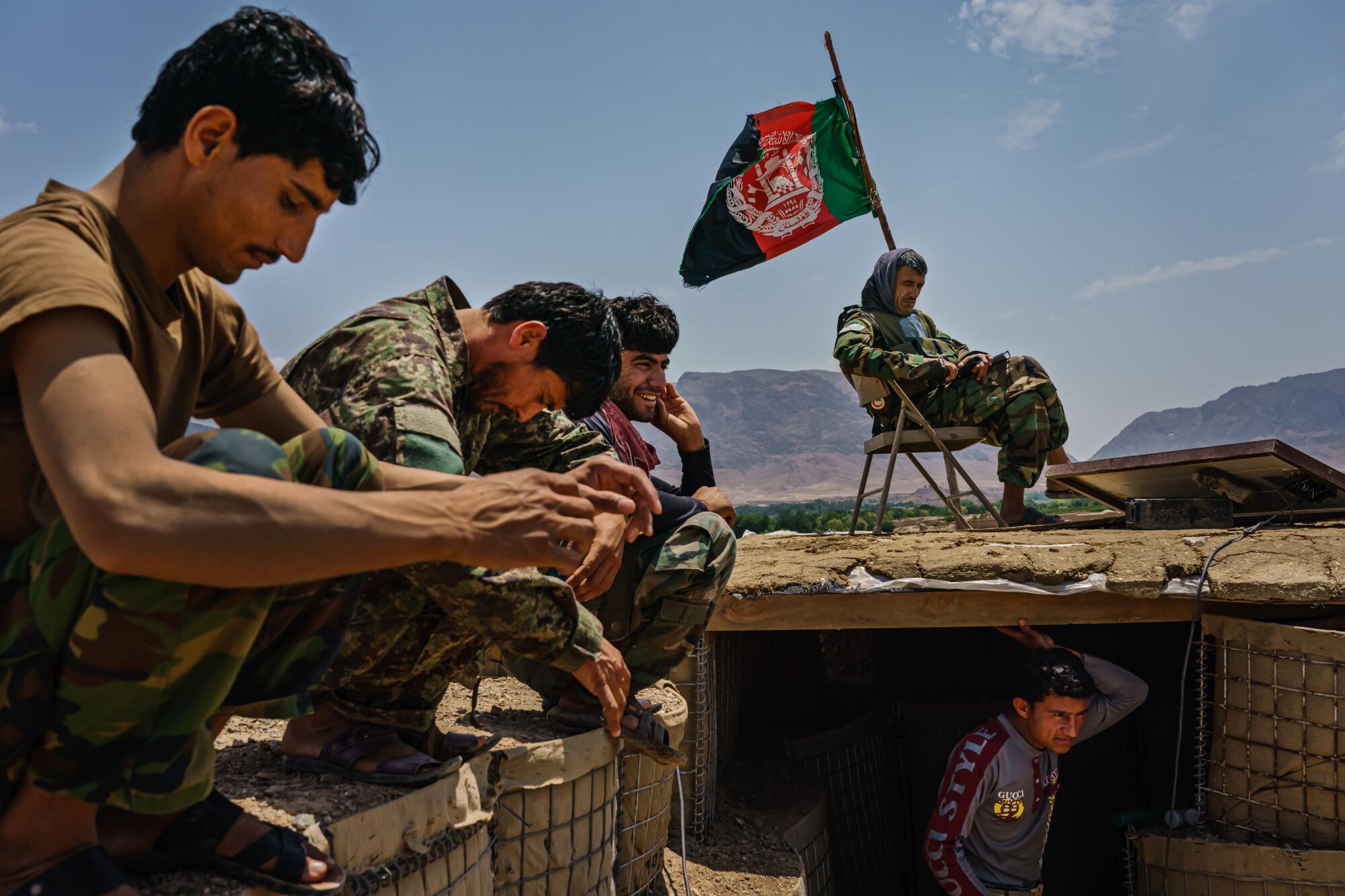 Soldiers sit outside at an Afghan National Army base
