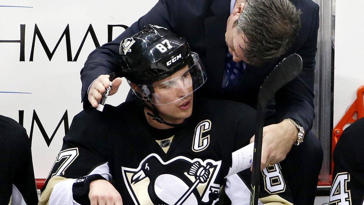 Penguins captain Sidney Crosby, who will sit out the start of the season because of a concussion, talks to Coach Mike Sullivan during a game last season.