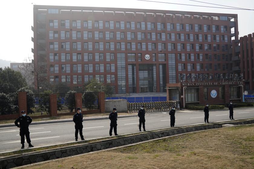 Security personnel gather near the entrance to the Wuhan Institute of Virology during a visit by the World Health Organization team in Wuhan in China's Hubei province on Wednesday, Feb. 3, 2021. The WHO team is investigating the origins of the coronavirus pandemic has visited two disease control centers in the province. (AP Photo/Ng Han Guan)