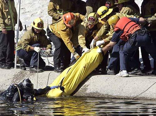 Los Angeles firefighters recover the body of a boy from the Los Angeles River in the Glassell Park area Tuesday, about two hours after witnesses reported seeing him go underwater. A bicycle and fishing pole were found at the scene.