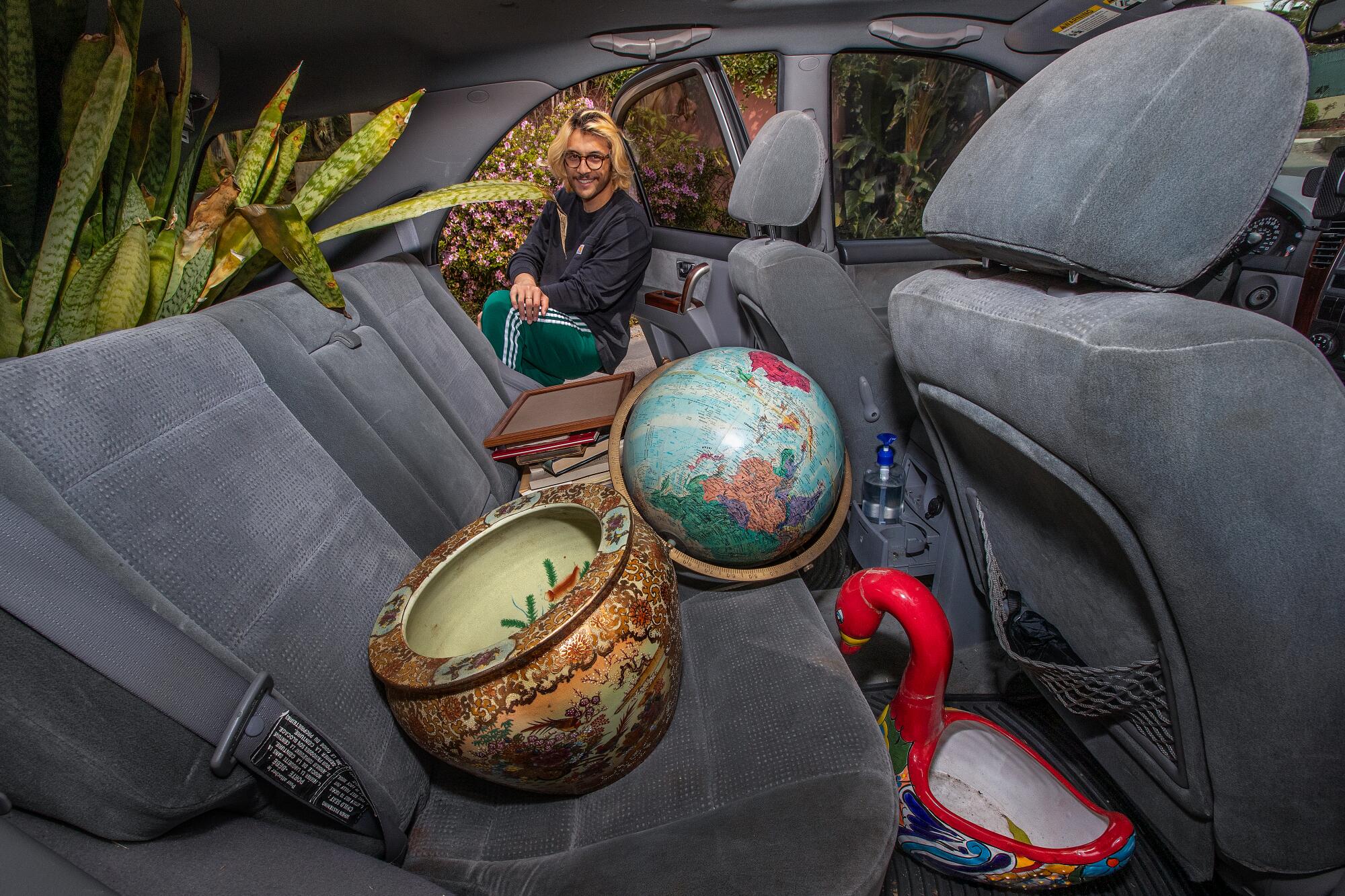 A back seat loaded with a globe, a Chinese bowl and a ceramic bird.