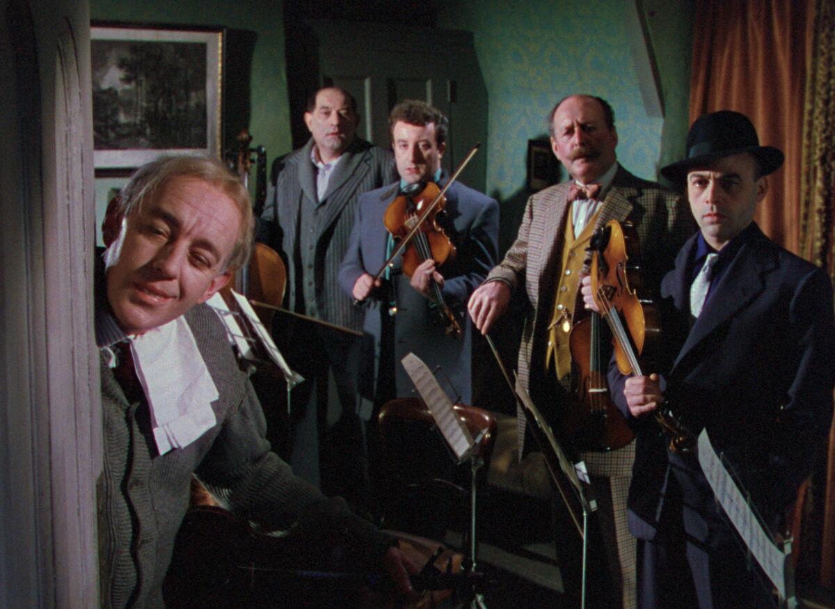 Men holding musical instruments look toward an opened door in the film "The Ladykillers"