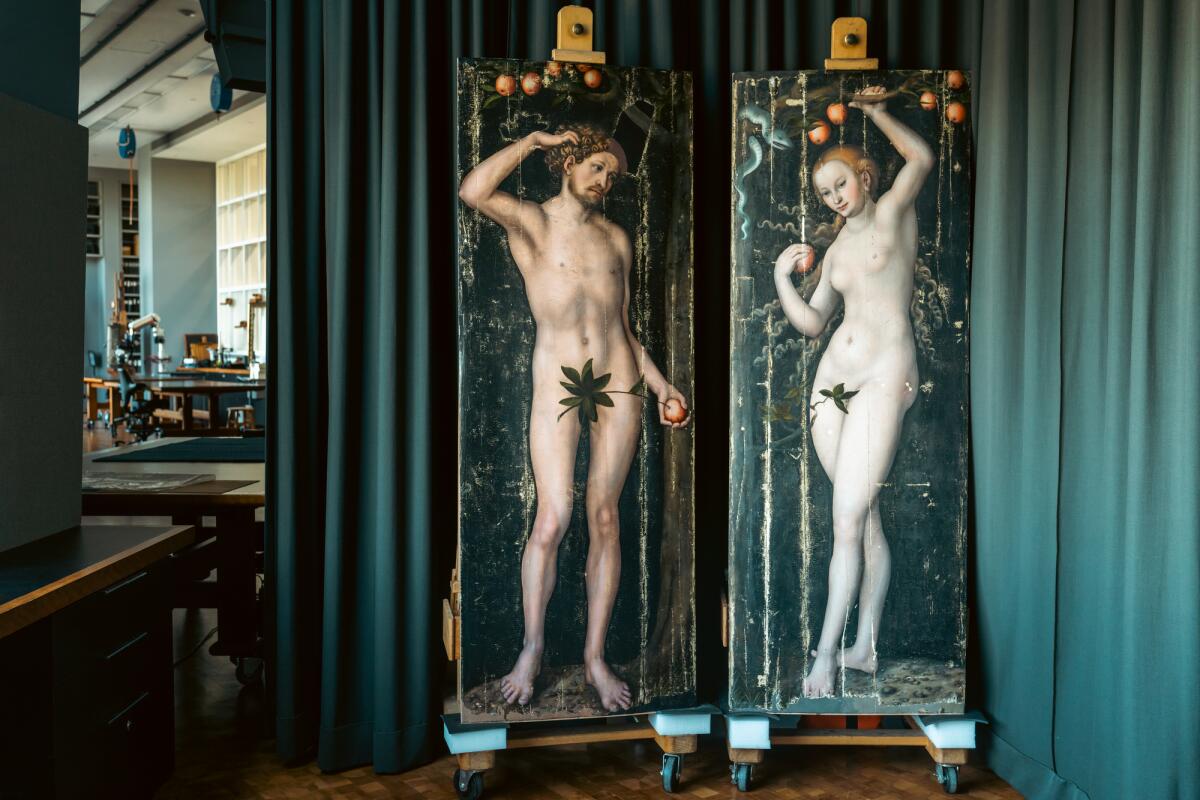 Lucas Cranach the Elder's 16th century panels showing a nude Adam and Eve stand on easels before a green curtain.