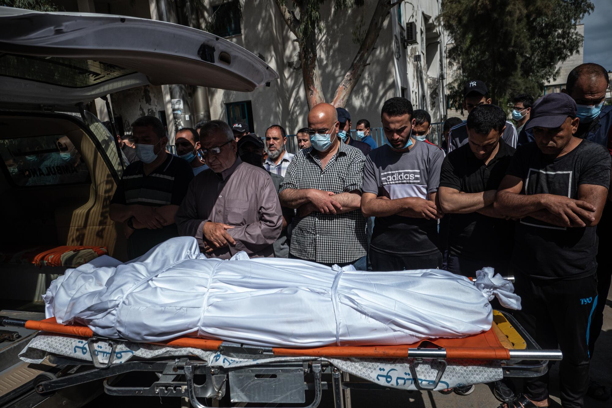 Palestinians perform funeral prayers over a wrapped body