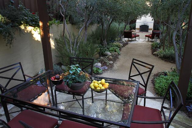 Another view of the outdoor fireplace through the olive allee.