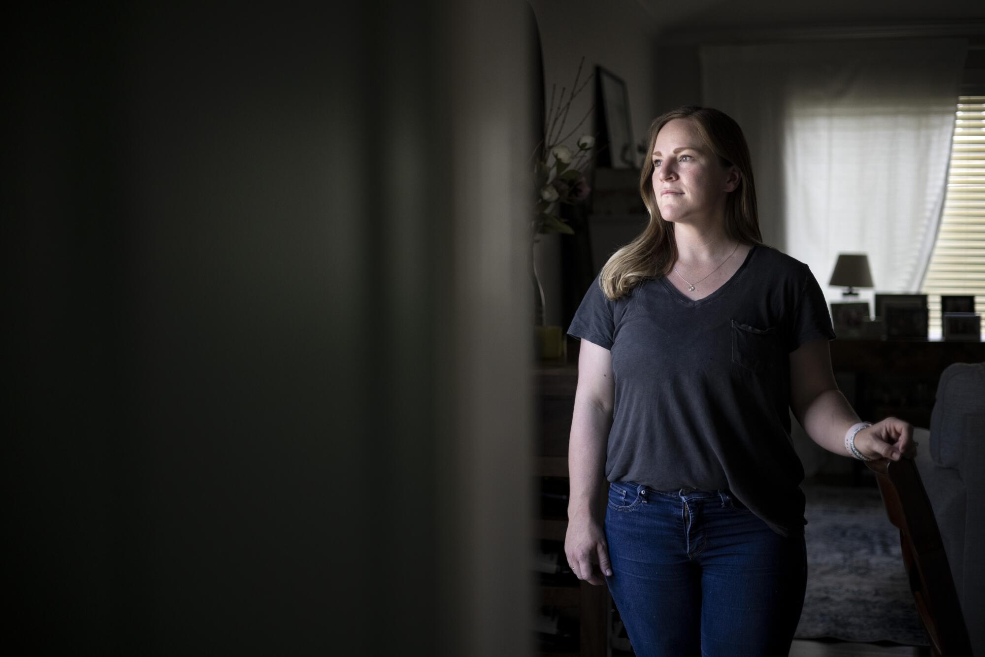 Katie Becker looks out the window at her home.