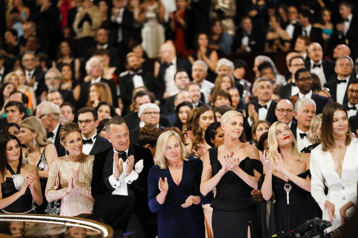 Rita Wilson, Tom Hanks and Charlize Theron react as Renée Zellweger wins the lead actress Oscar for “Judy” in February.