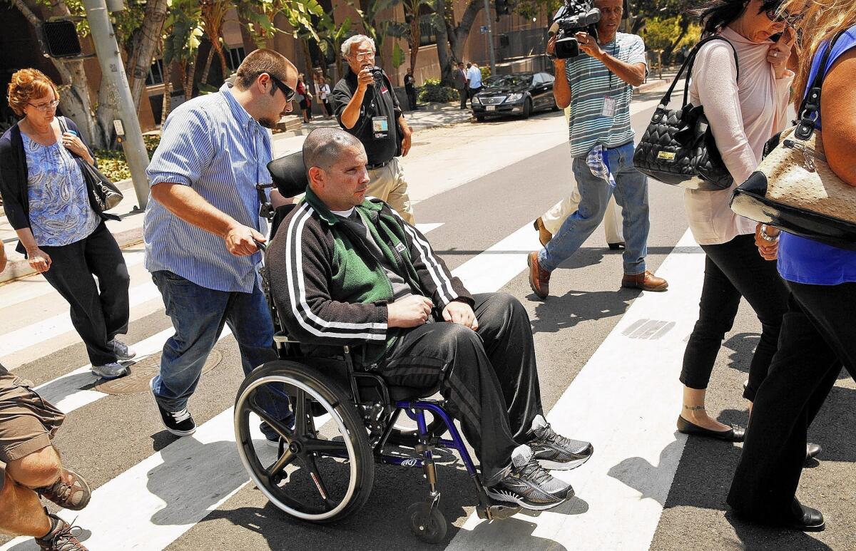 Bryan Stow is assisted by a caregiver as he leaves court on May 28.