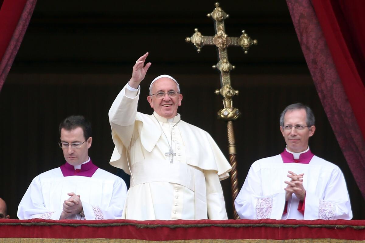Pope Francis waves to the faithful as he delivers his Christmas Day message from the central balcony of St Peter's Basilica in Vatican City.
