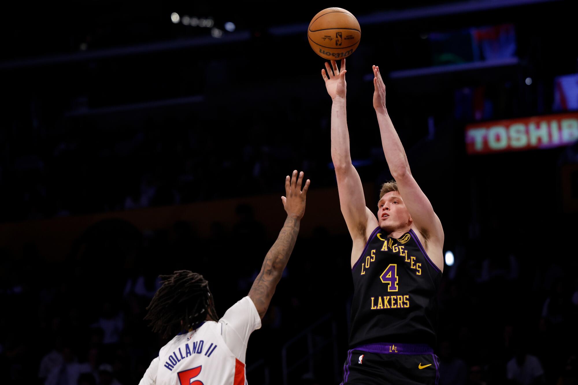 Lakers forveti Dalton Knecht, Detroit Pistons forveti Ronald Holland II tarafından savunulurken şut atmak için uzanıyor.