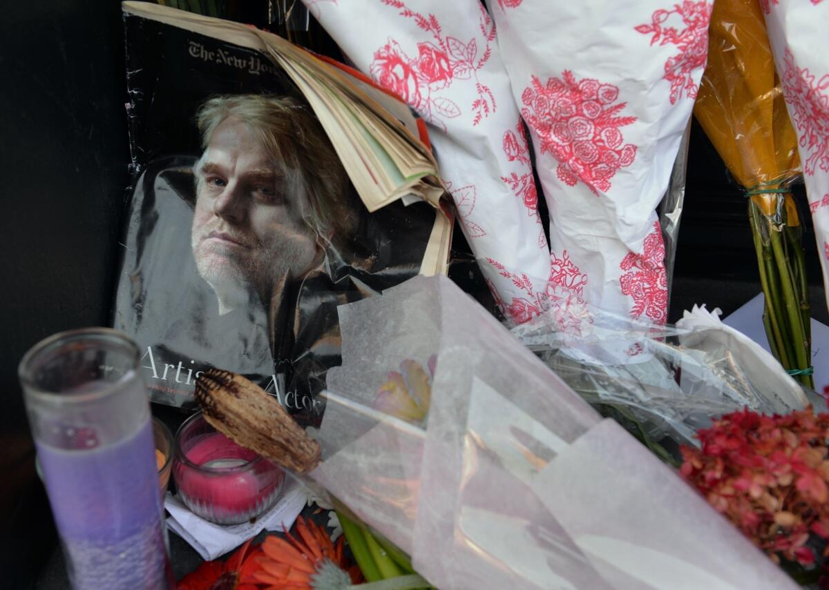 A magazine with Philip Seymour Hoffman on the cover and flowers are placed at a makeshift memorial for the actor at the entrance of the apartment building where he died in New York's West Village neighborhood.