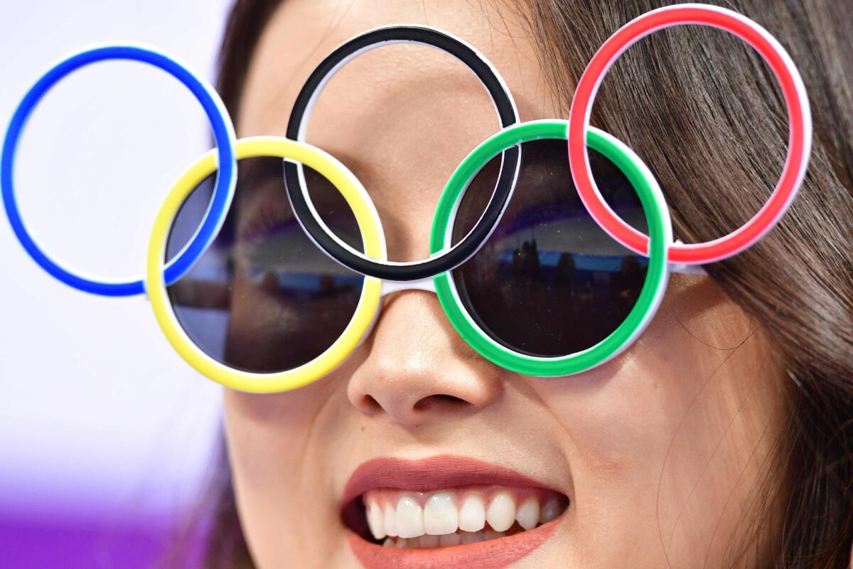 A woman wears Olympic rings sunglasses during the figure skating team event men's single skating short program during the Pyeongchang 2018 Winter Olympic Games at the Gangneung Ice Arena in Gangneung on February 9, 2018.