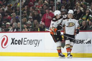 Anaheim Ducks right wing Troy Terry, right, celebrates with center Leo Carlsson.