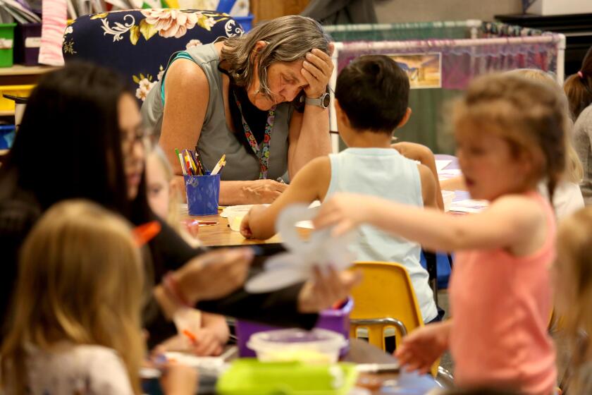 ALTURAS, CA - MAY 18, 2023 - Teachers assistant Eleanor Dorton, center, works with students during a combined TK and kindergarten class at Alturas Elementary School in Alturas, California, on May 18, 2023. The TK class gained 9 kindergarteners when a fellow teacher quit on a Sunday night a few weeks ago. Schools in Alturas are suffering a dire teacher shortage that is subject to get worse with the state's addition of required transitional Kindergarten. Administrators are so desperate they're going to recruiting fairs in North Dakota to try and get teachers for their schools. (Genaro Molina / Los Angeles Times)