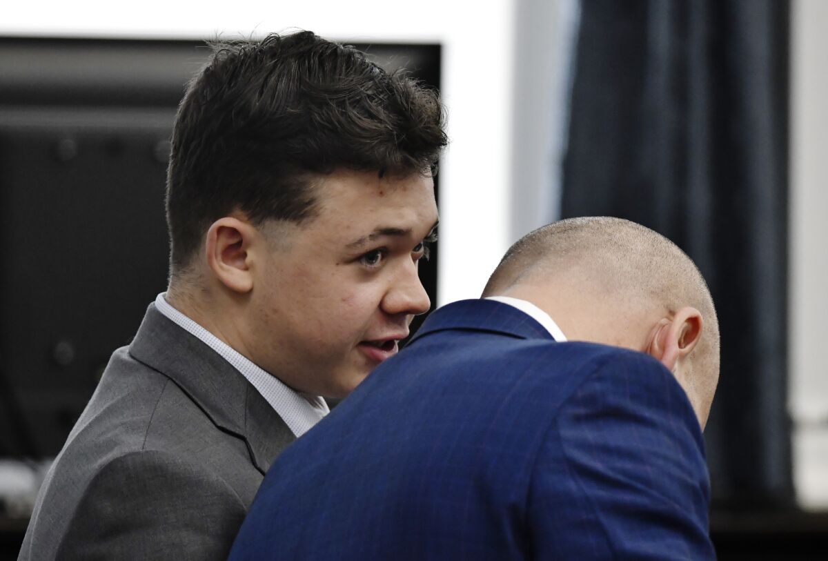 Kyle Rittenhouse, left, speaks with one of his attorneys.