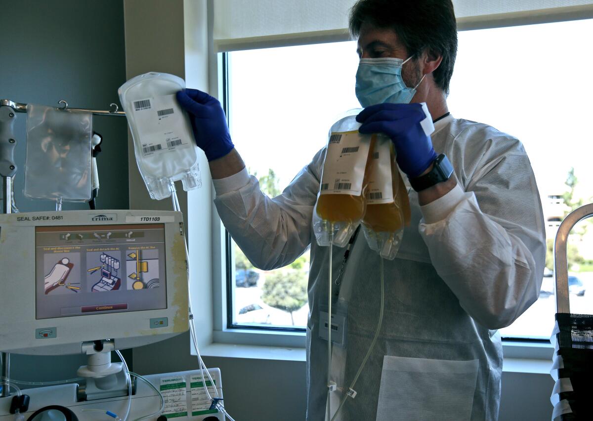 Phlebotomist Paul Posey retrieves bags of plasma taken from Newport Beach resident Glenn Walcott at Irvine's Hoag Health Center Tuesday.