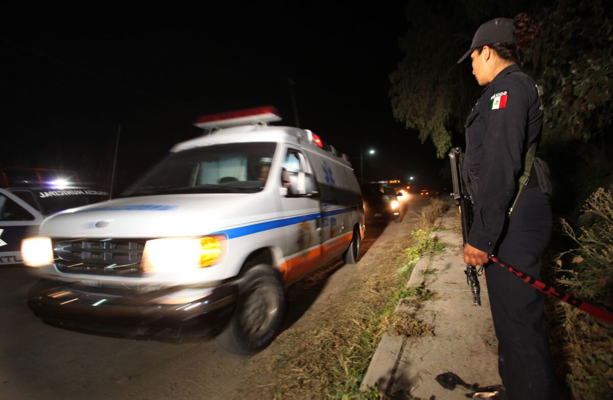 A police agent stands guard as an ambulance leaves the village of Hueypoxtla, Mexico. Mexican troops and federal police kept a nighttime vigil guarding a rural field where thieves had abandoned a stolen shipment of highly radioactive cobalt-60.